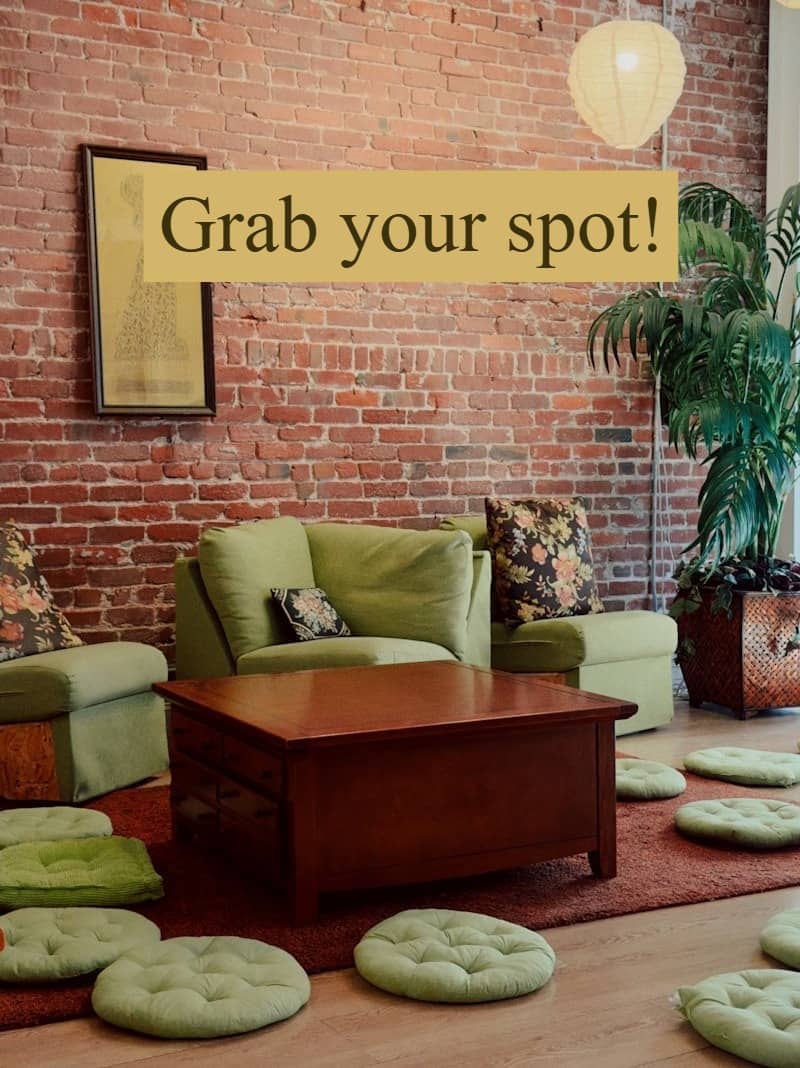 Cozy room with brick wall, green furniture, and floor cushions.