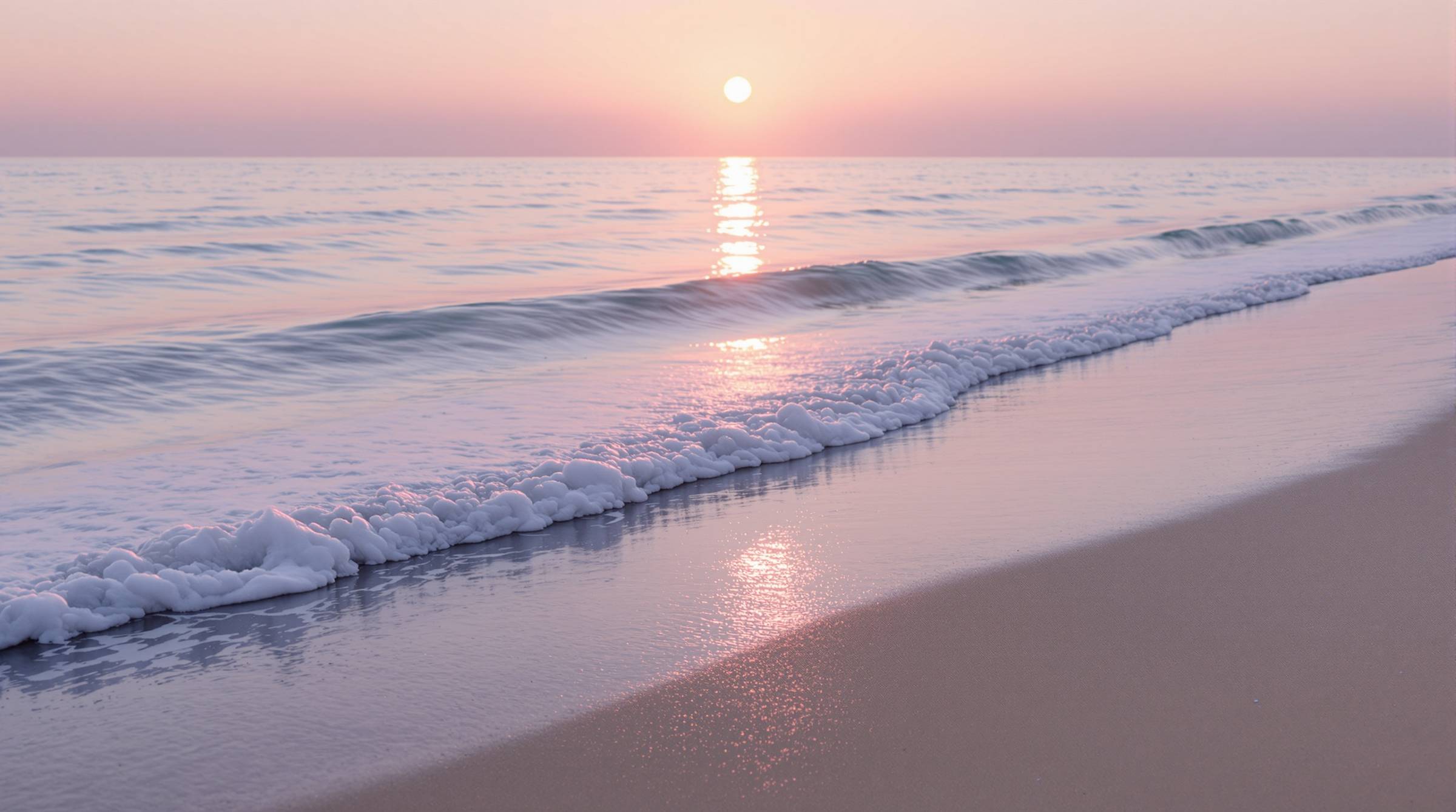 Soft sunrise over a calm ocean shoreline.