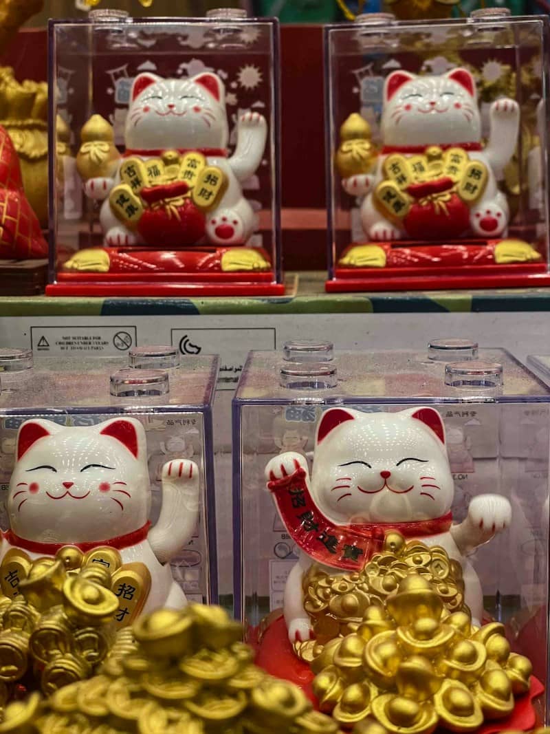Four lucky cat figurines with gold coins