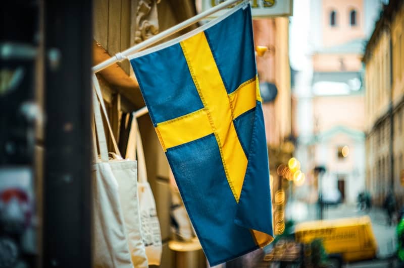 A swedish flag hangs outside a shop.