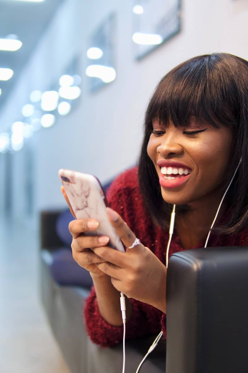 woman in pink shirt holding white smartphone