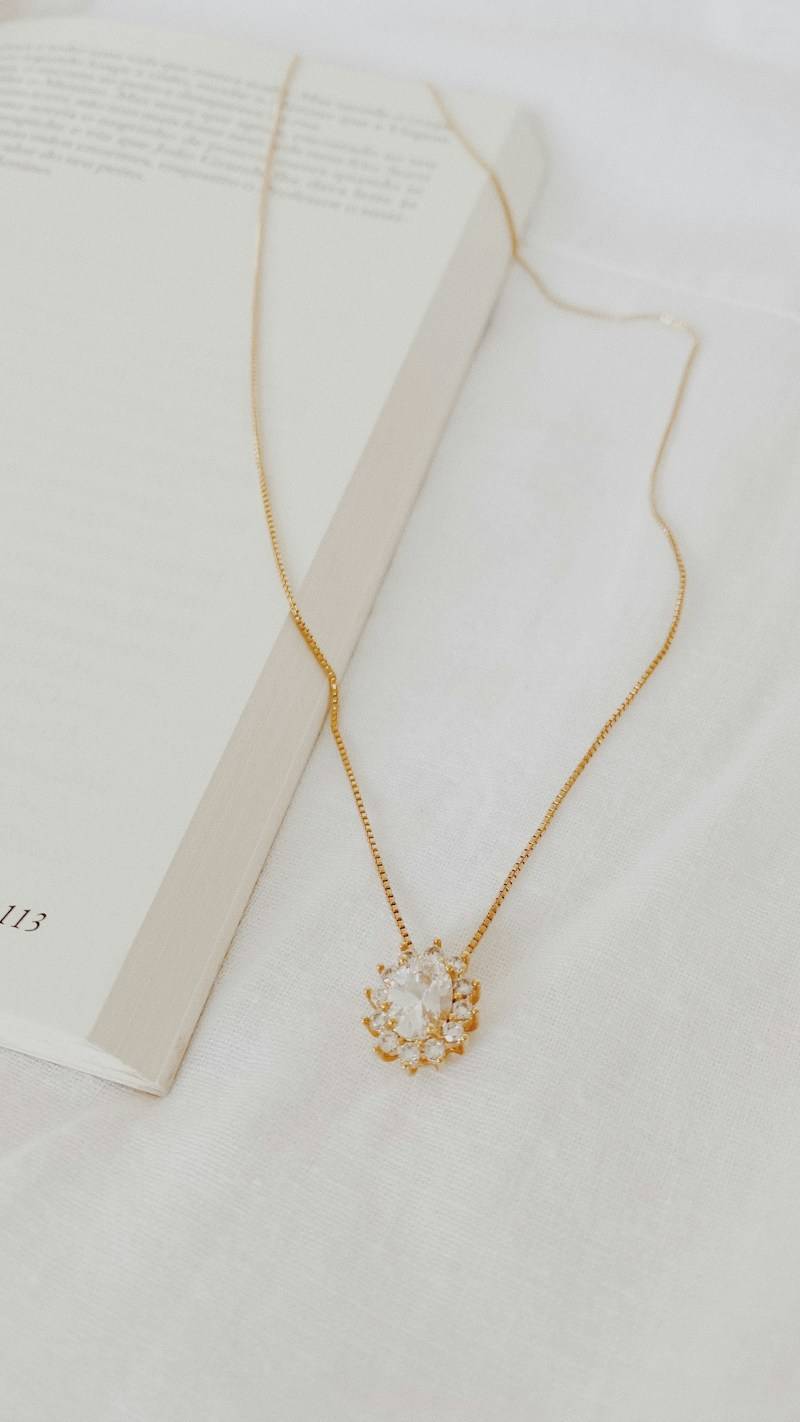 gold necklace on white paper
