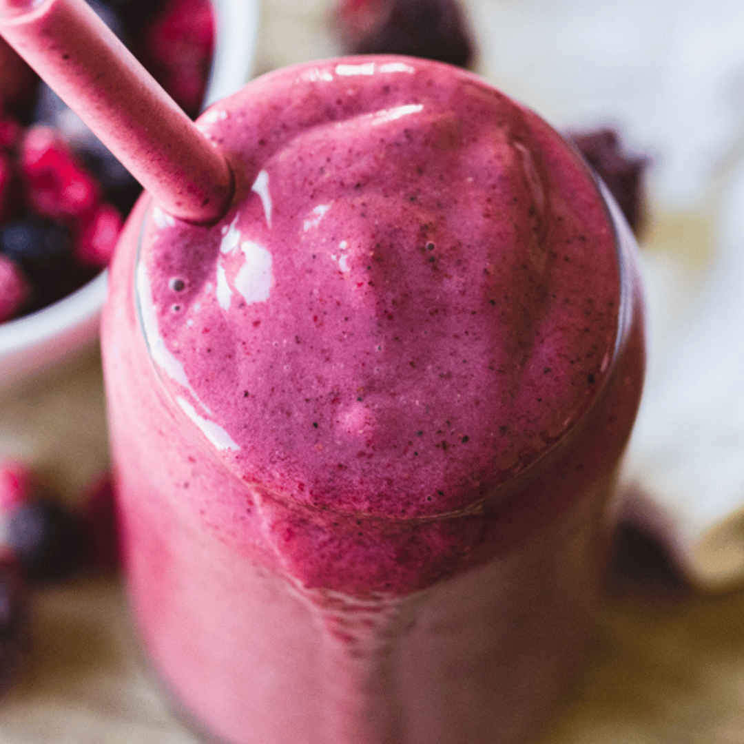 purple smoothie served in a cup with straw