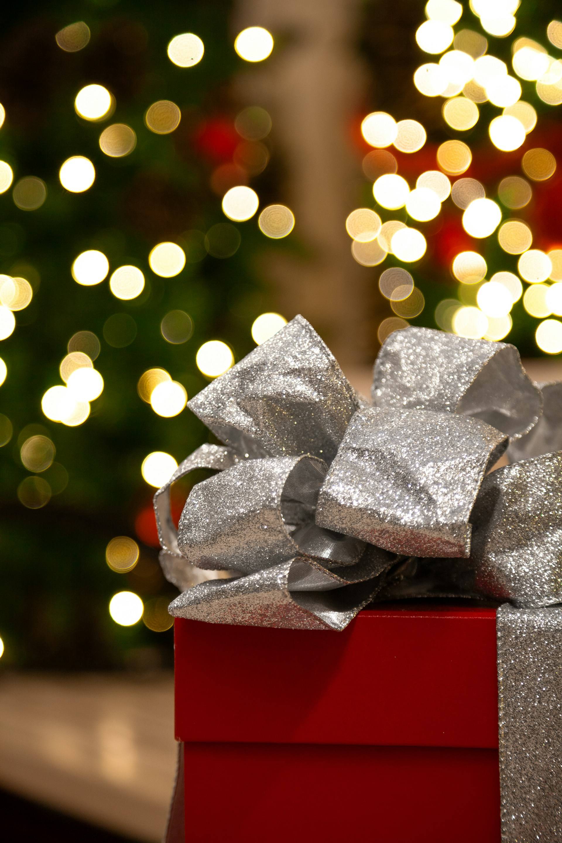 A beautifully wrapped gift in red paper with a silver bow.