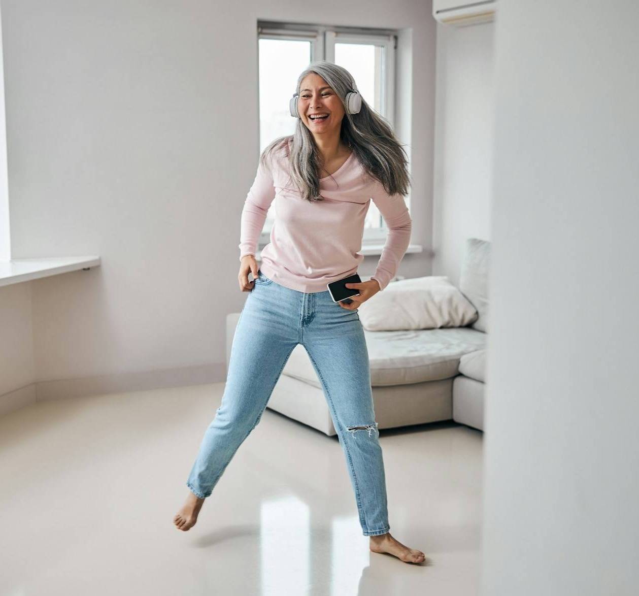 A woman in midlife dancing to headphones as she reinvents her routine.