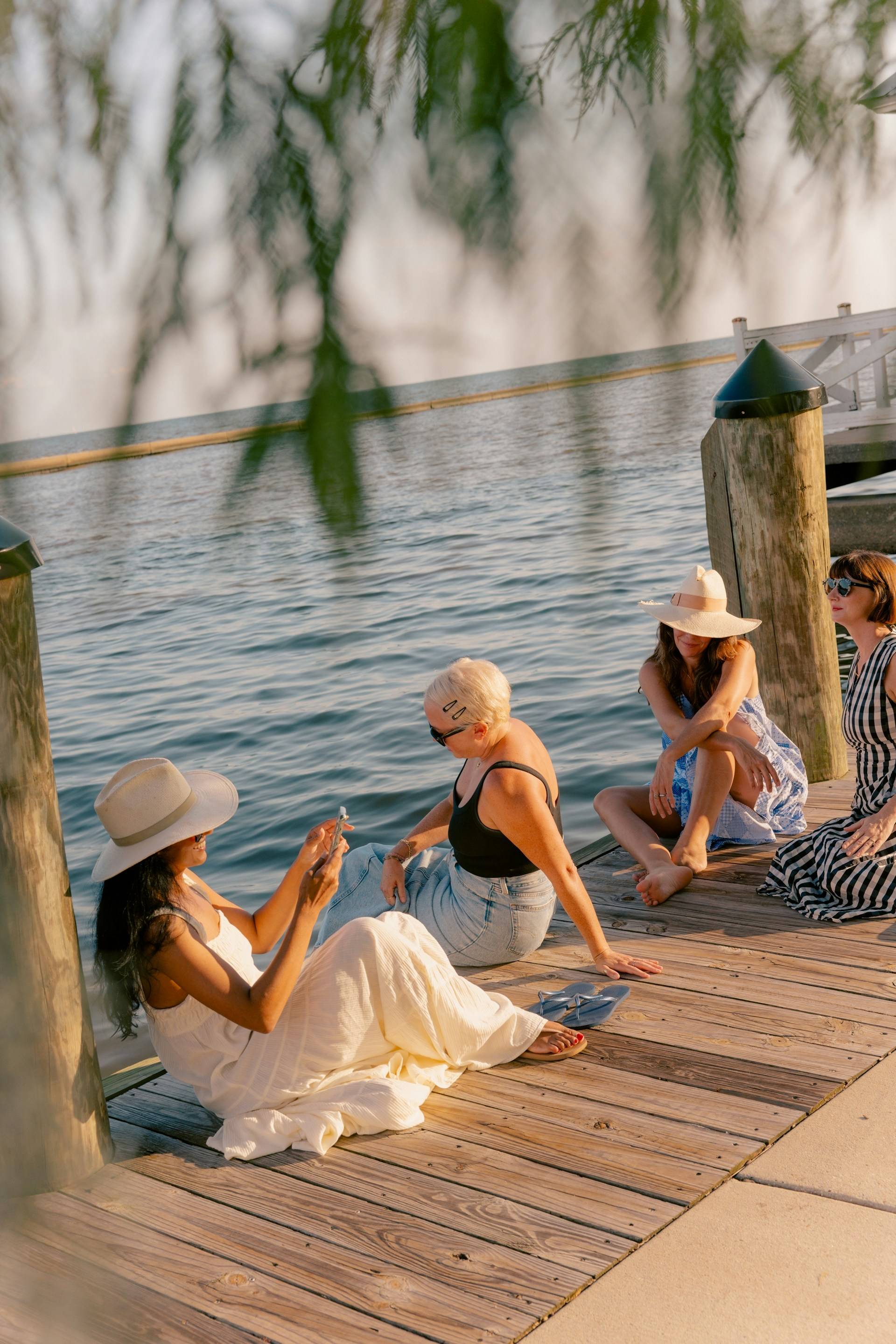 Three women sitting on a dock purposely doing nothing on Labor Day Weekend.