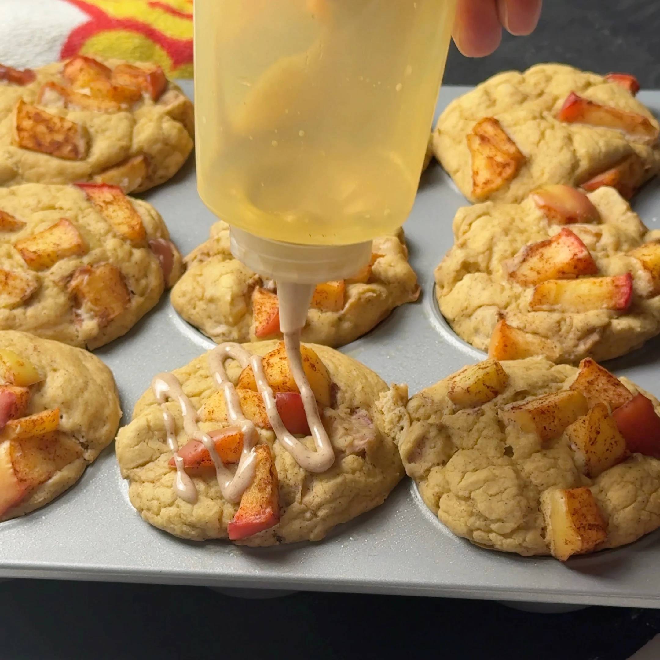 Apple pie protein muffins being finished with cinnamon glaze