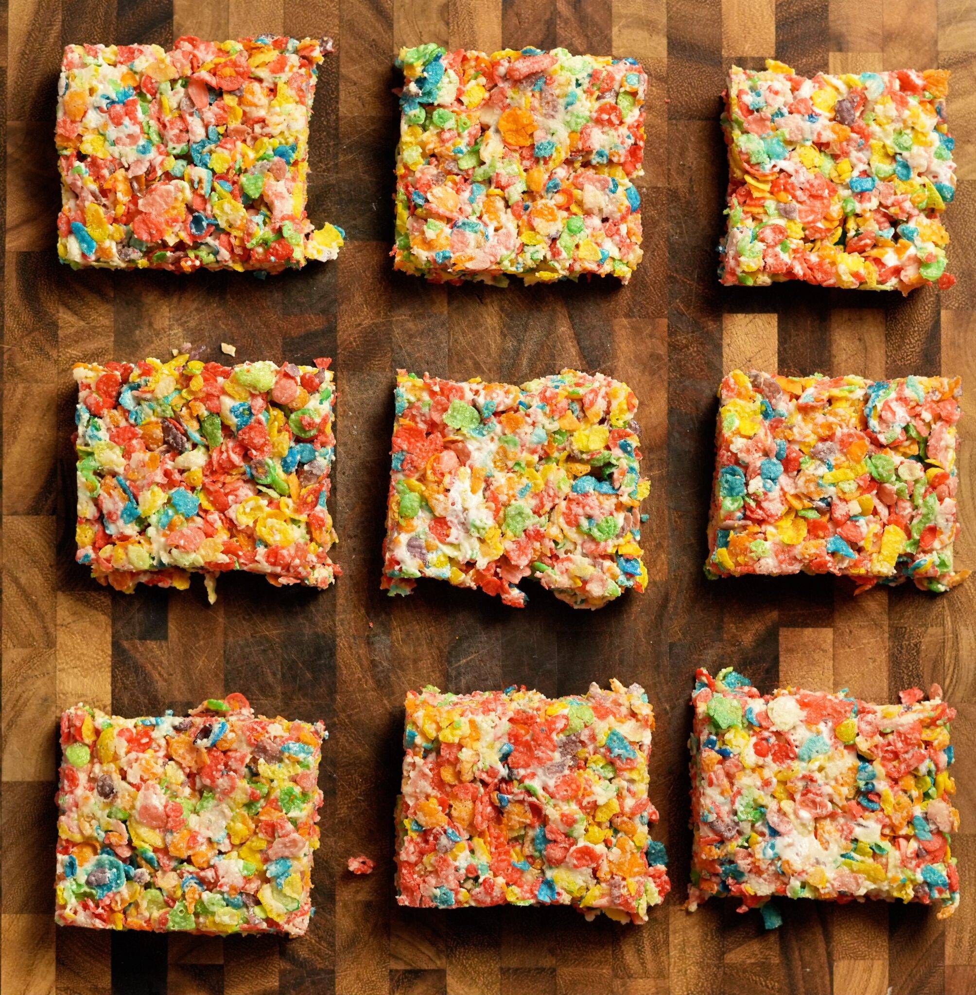 Colorful BakedLean cereal treats arranged on a wooden board