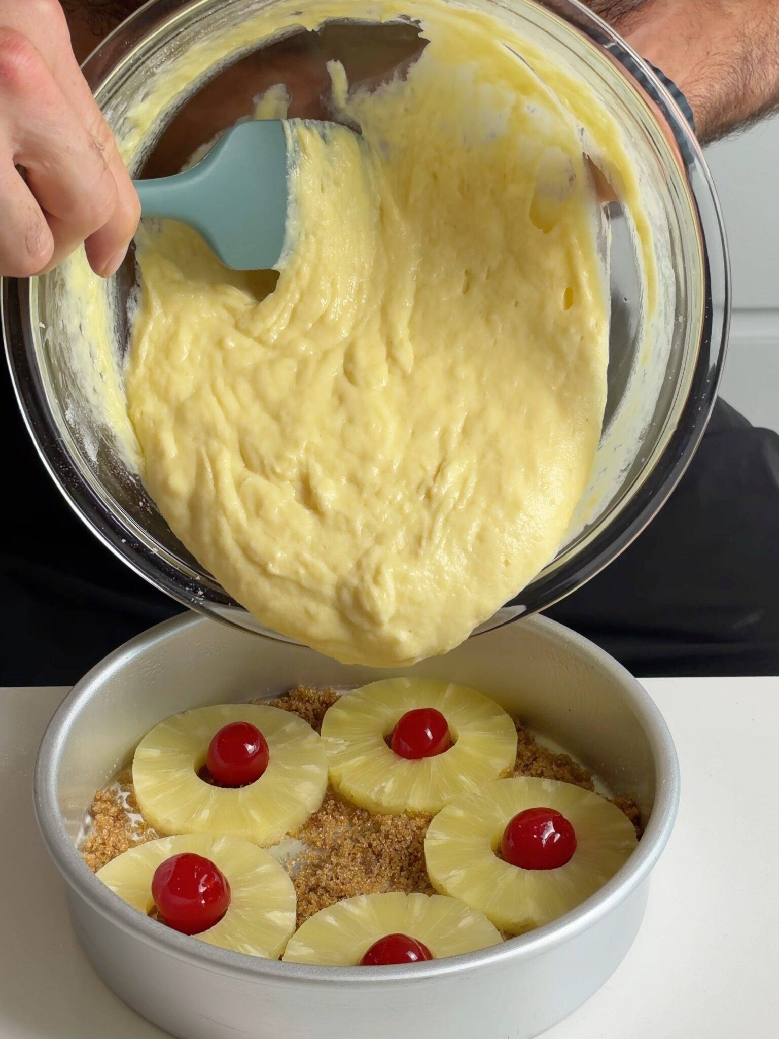 009 Upside-Down Cake 1 — pouring cake batter over pineapple rings and cherries