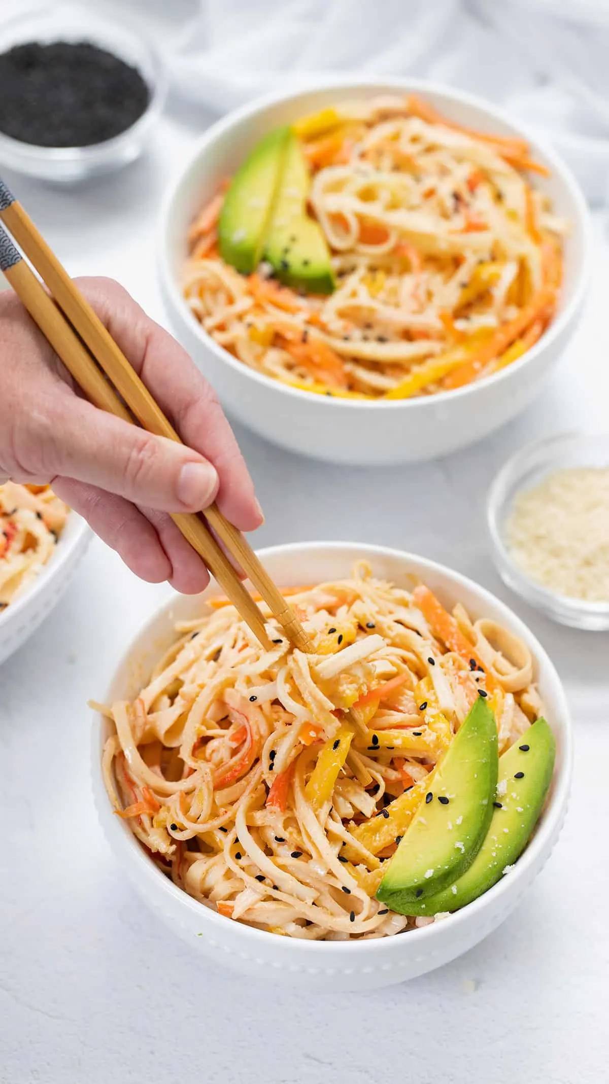 image of chop stix in hand pinching a bite of Kani salad