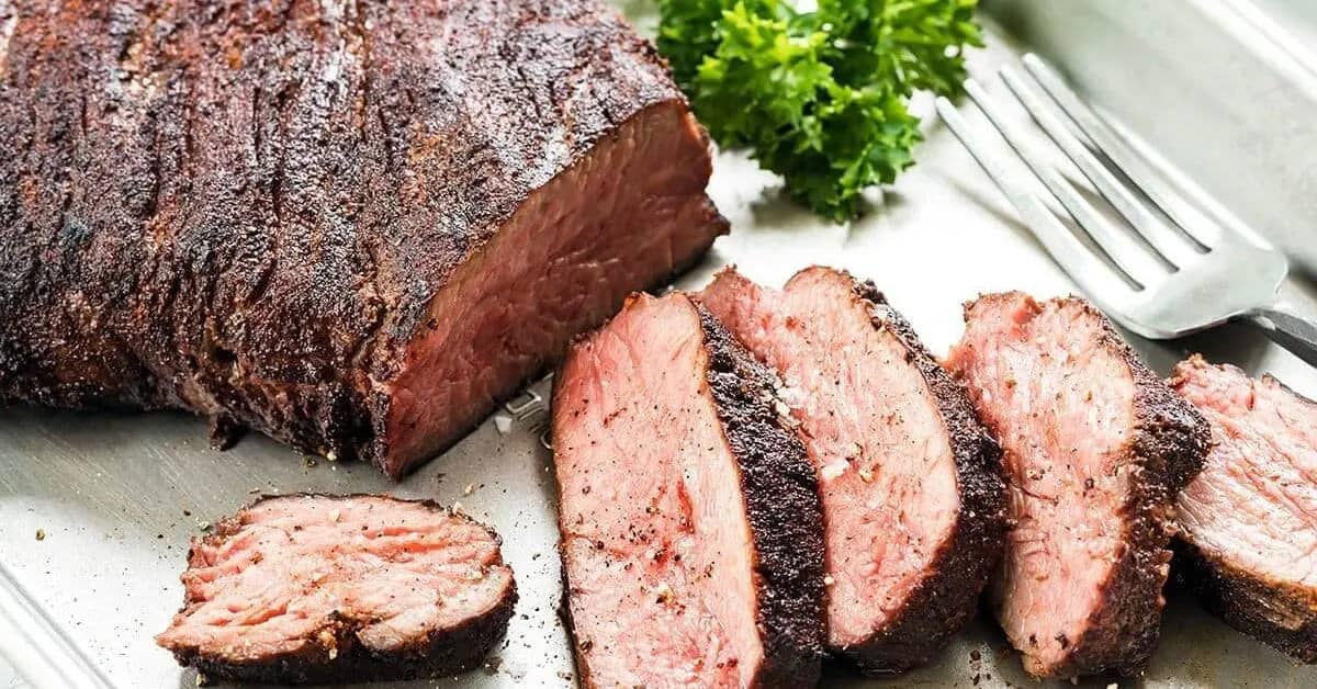 Sous Vide Leg of Lamb, with a flavorful garlic herb rub and garlic butter sauce in a metallic prep tray