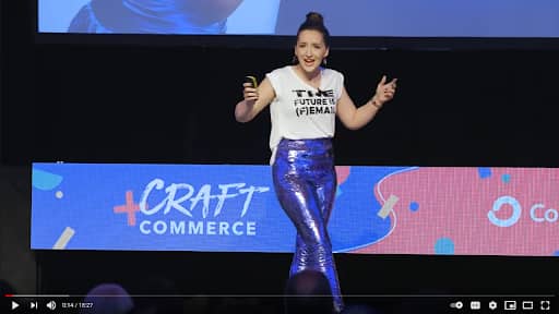 Tarzan Kay delivering a keynote presentation at the Craft + Commerce conference, engaging an audience of entrepreneurs and creators with expertise in copywriting, ethical marketing, and online business growth.