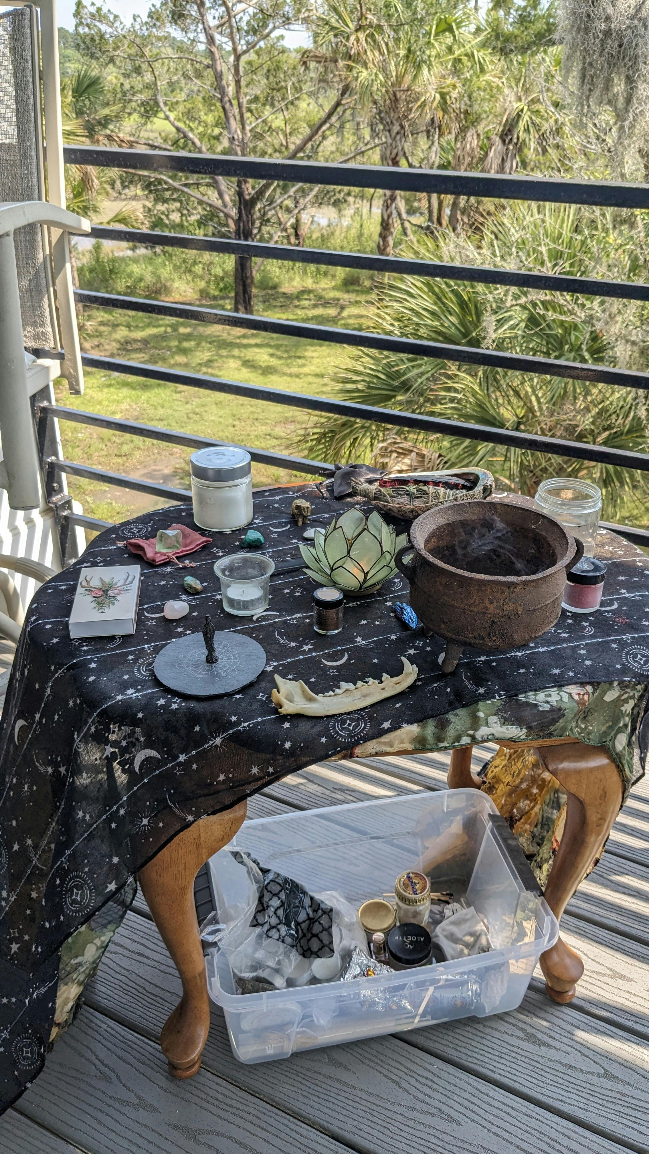 an outdoor altar bearing bones, a cauldron, some candles, and other treasures