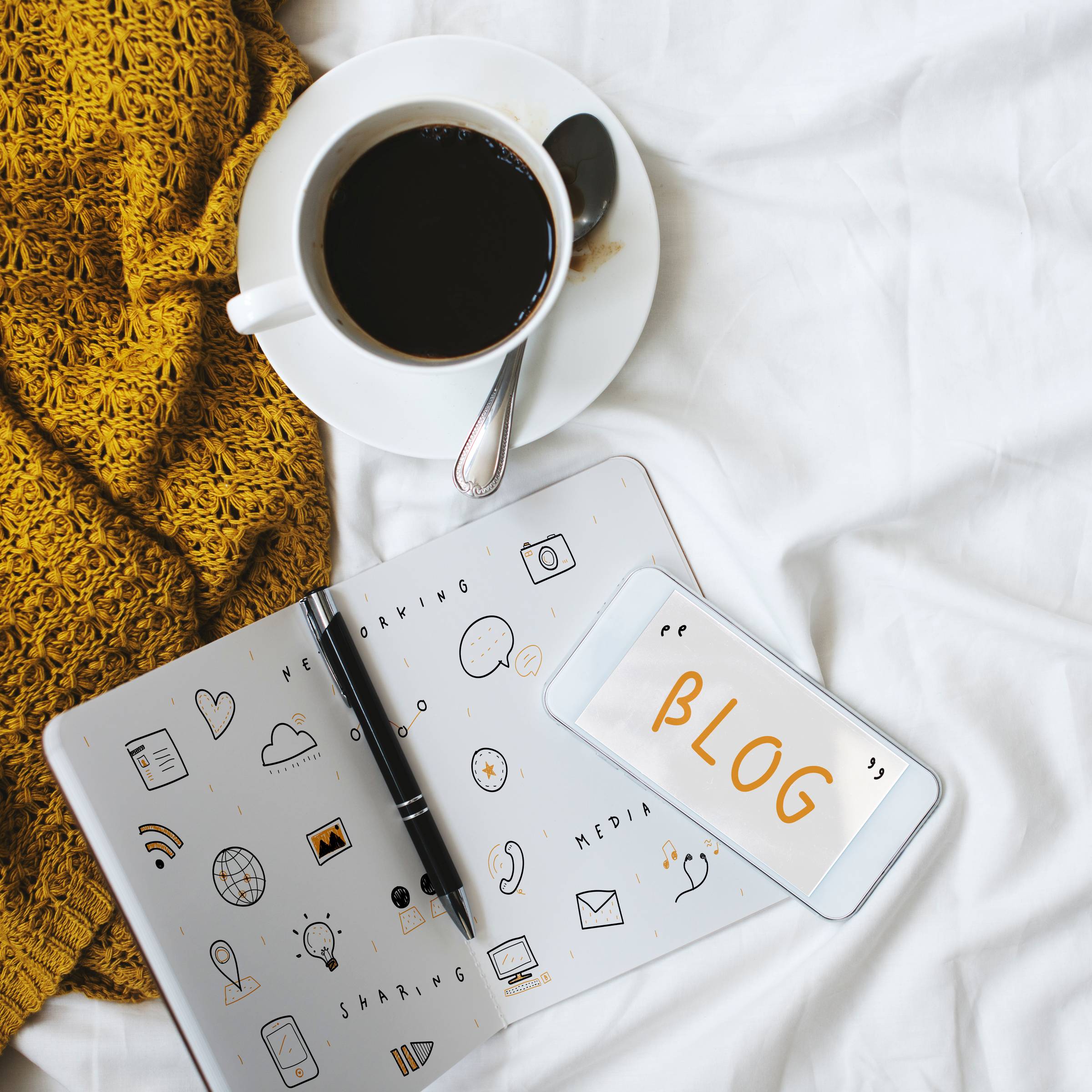 tea cup with a notebook with doodles and blog written