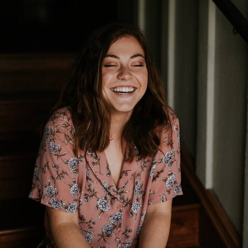 woman sitting on wooden stair smiling