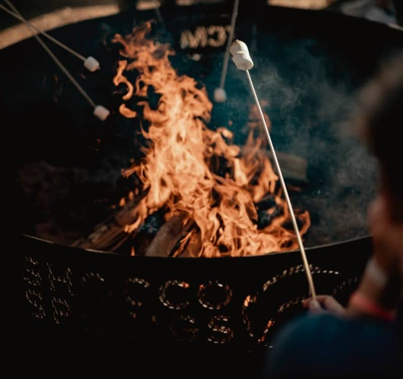 A fire pit with a bunch of people around it