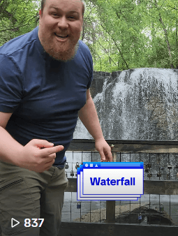 white guy standing in front of waterfall with onscreen caption "waterfall"
