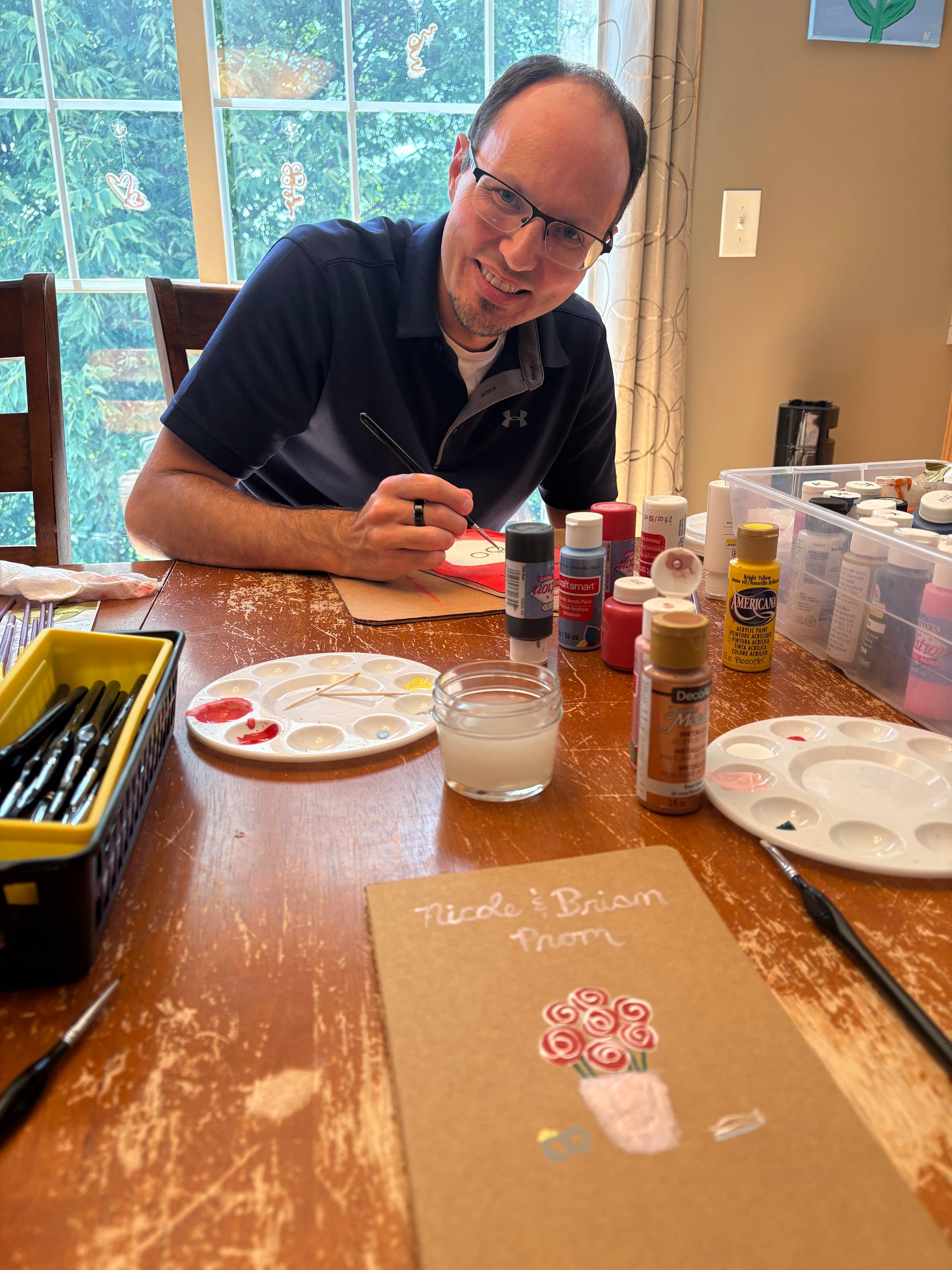 My husband working on the craft project he came up with for us with my project in near the camera.