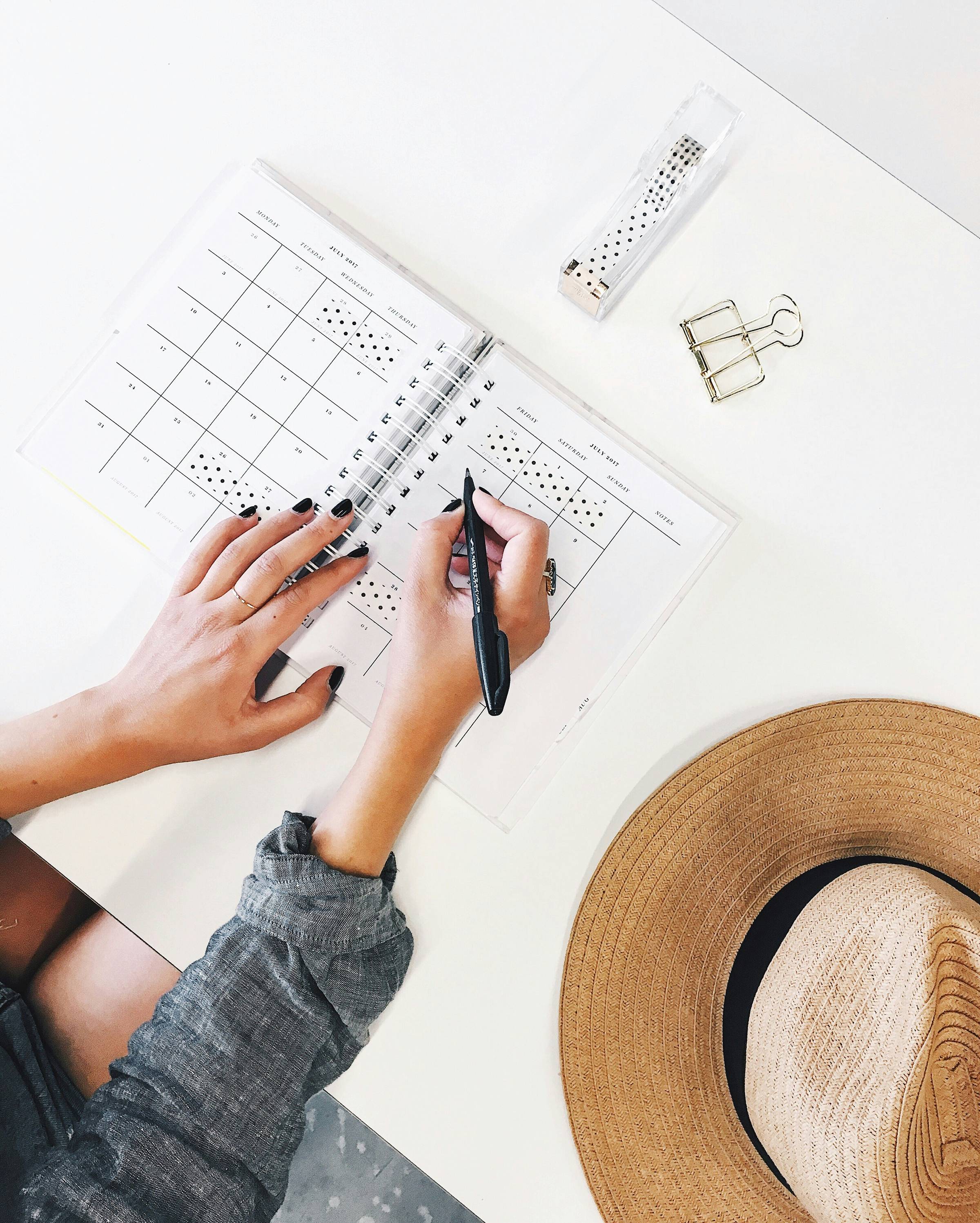 A woman's hand writing in a calendar