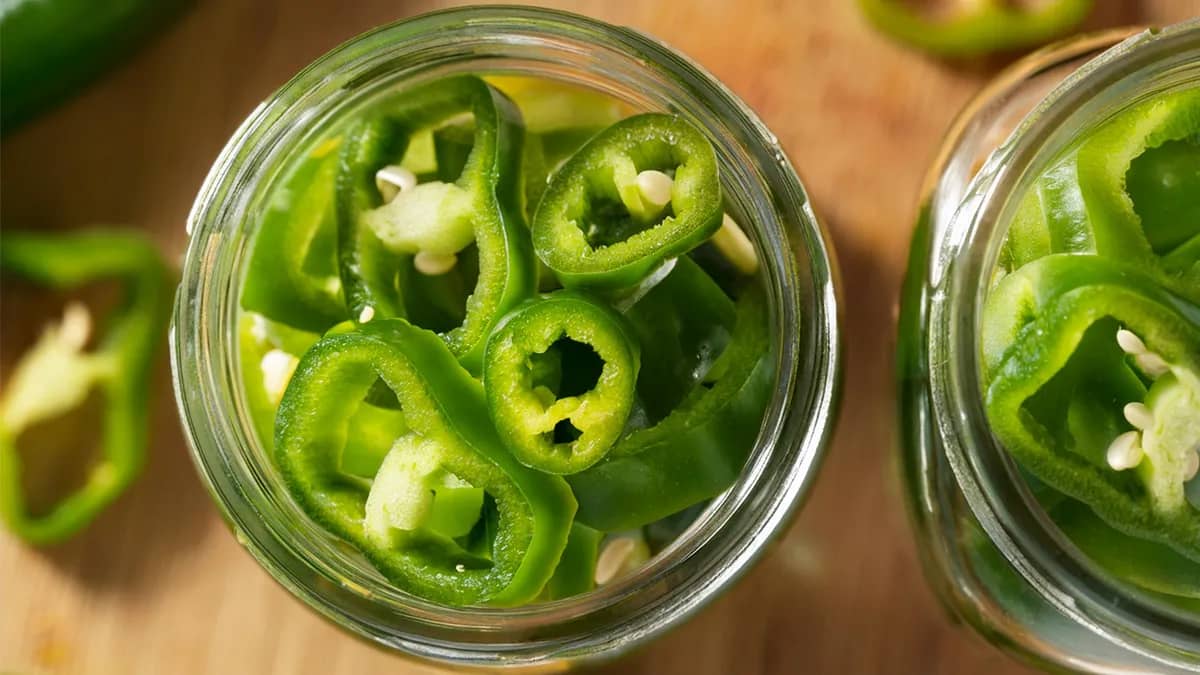 Sliced Hatch Pepper rings in a glass mason jar.