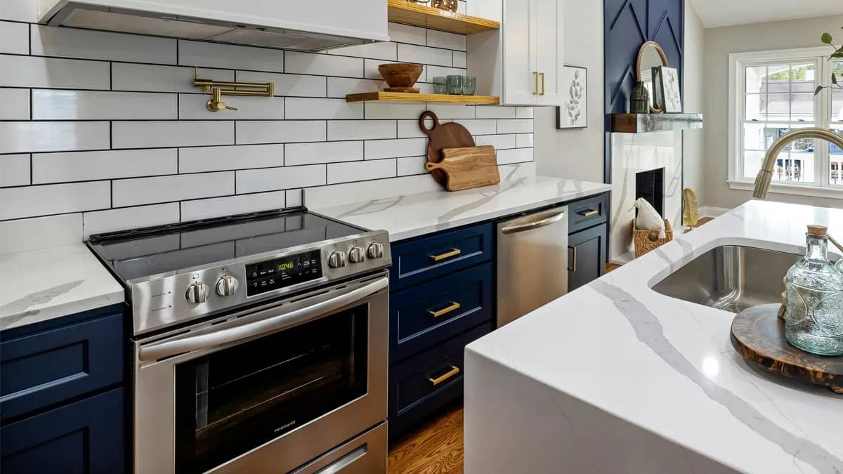 Glass-topped stove in a kitchen that is navy blue, white and gold.