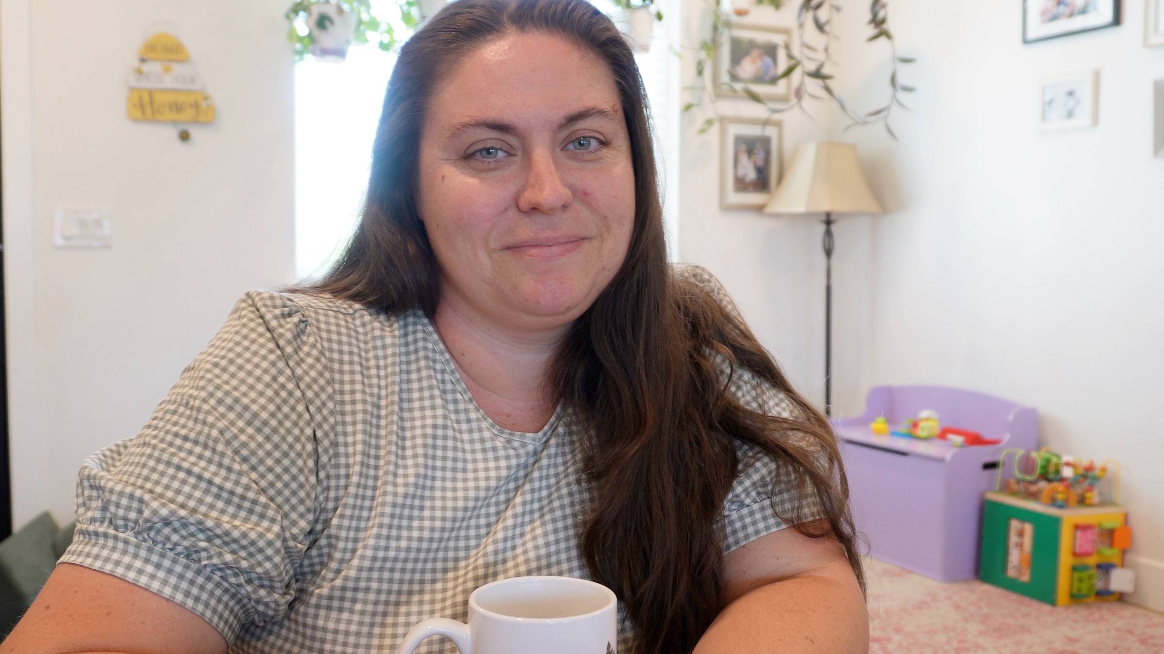 Serra Blaine RN BSN holding a cup of tea smiling 