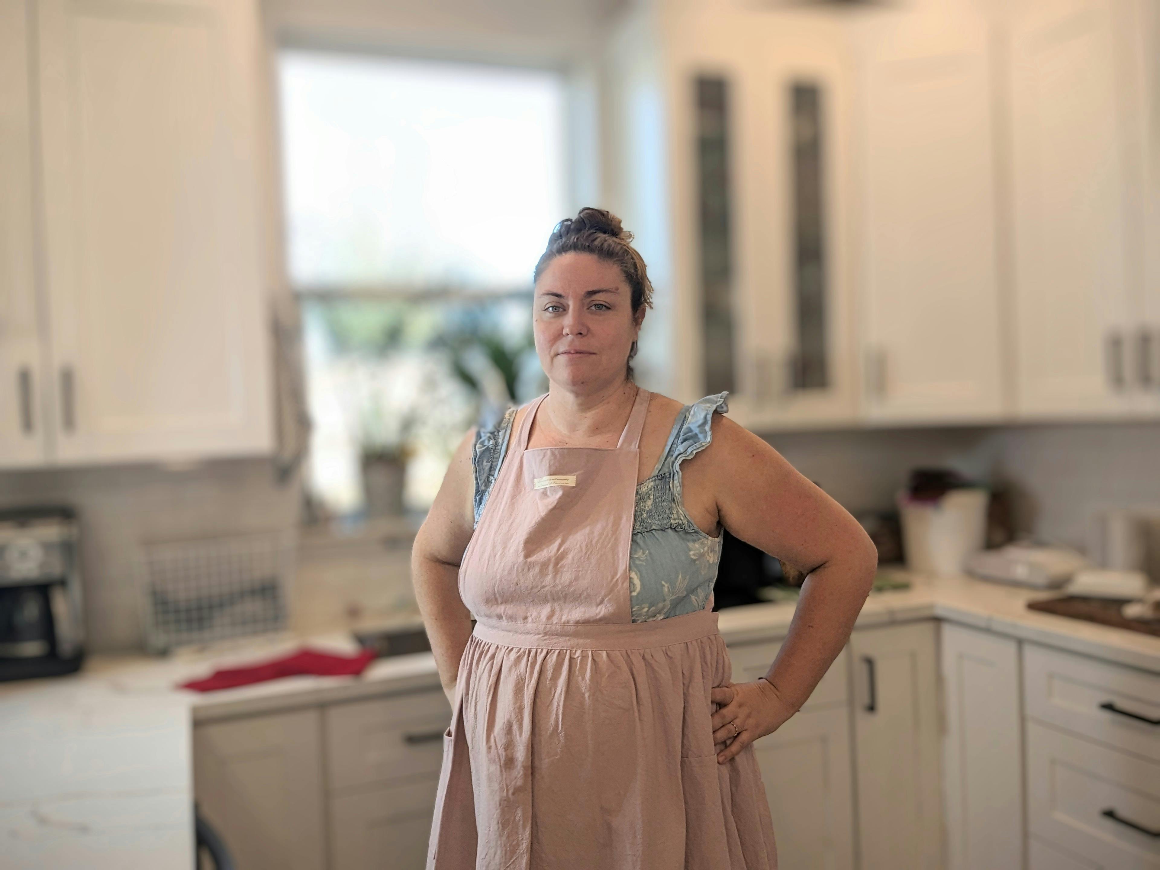 woman in pink apron standing in kitchen