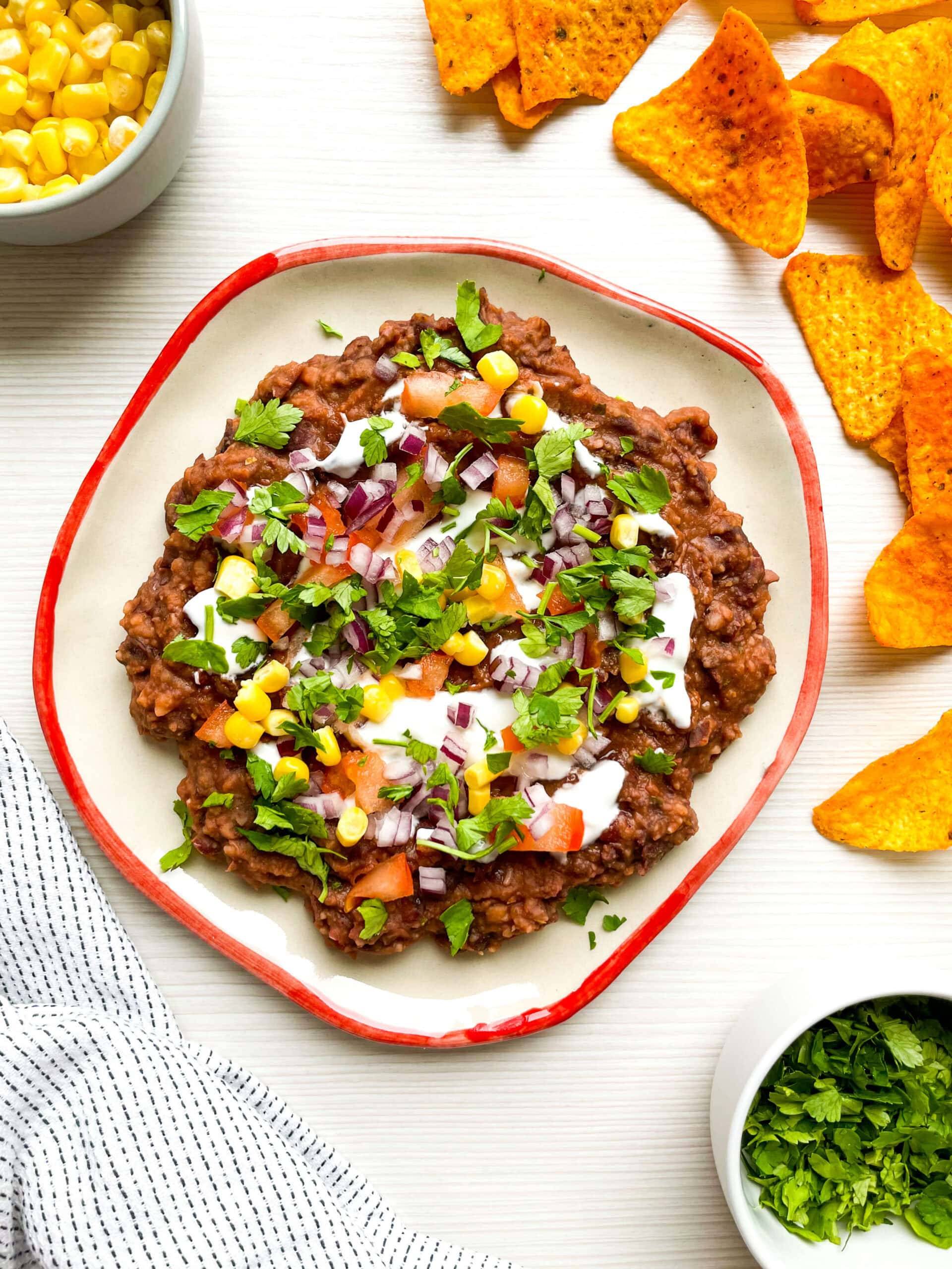 a spread of cowboy caviar with chips bordering it.