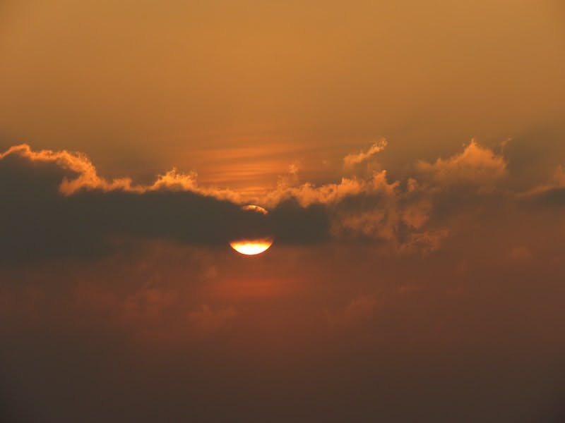 sun covered by clouds at sunset