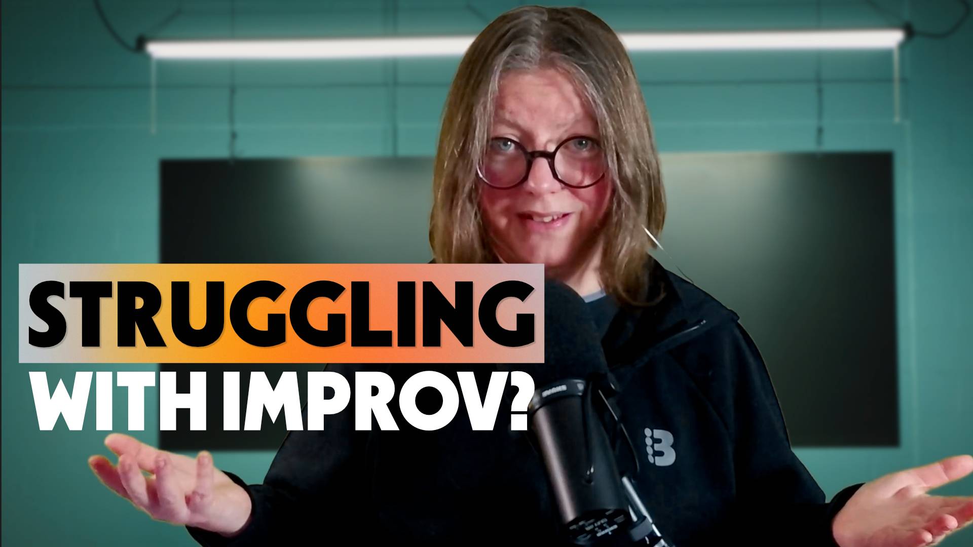 Jen standing in front of a teal wall behind a microphone with the text "Struggling with improv?" on the image.