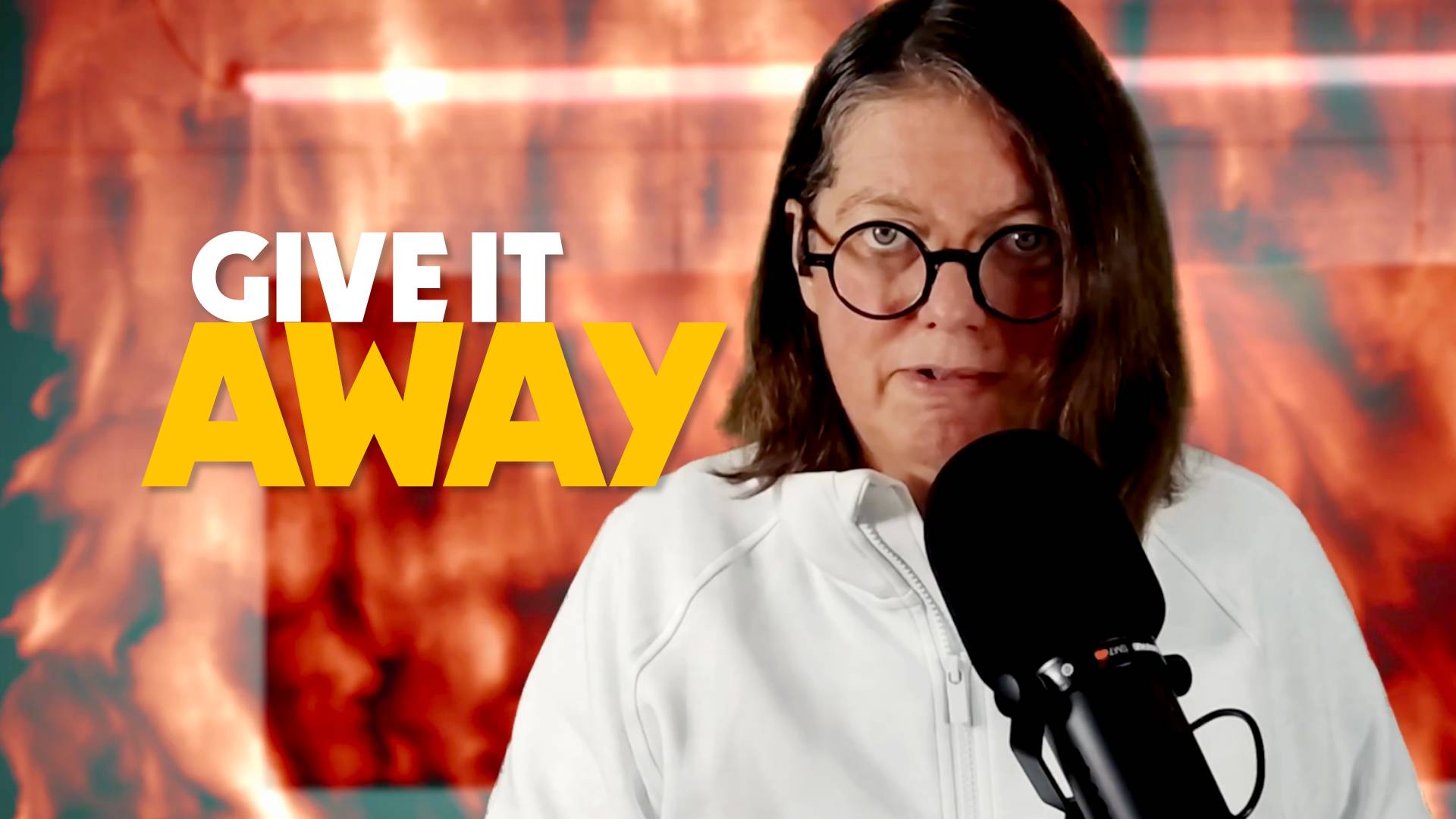 Jen behind microphone with flames in background with text "give it away"