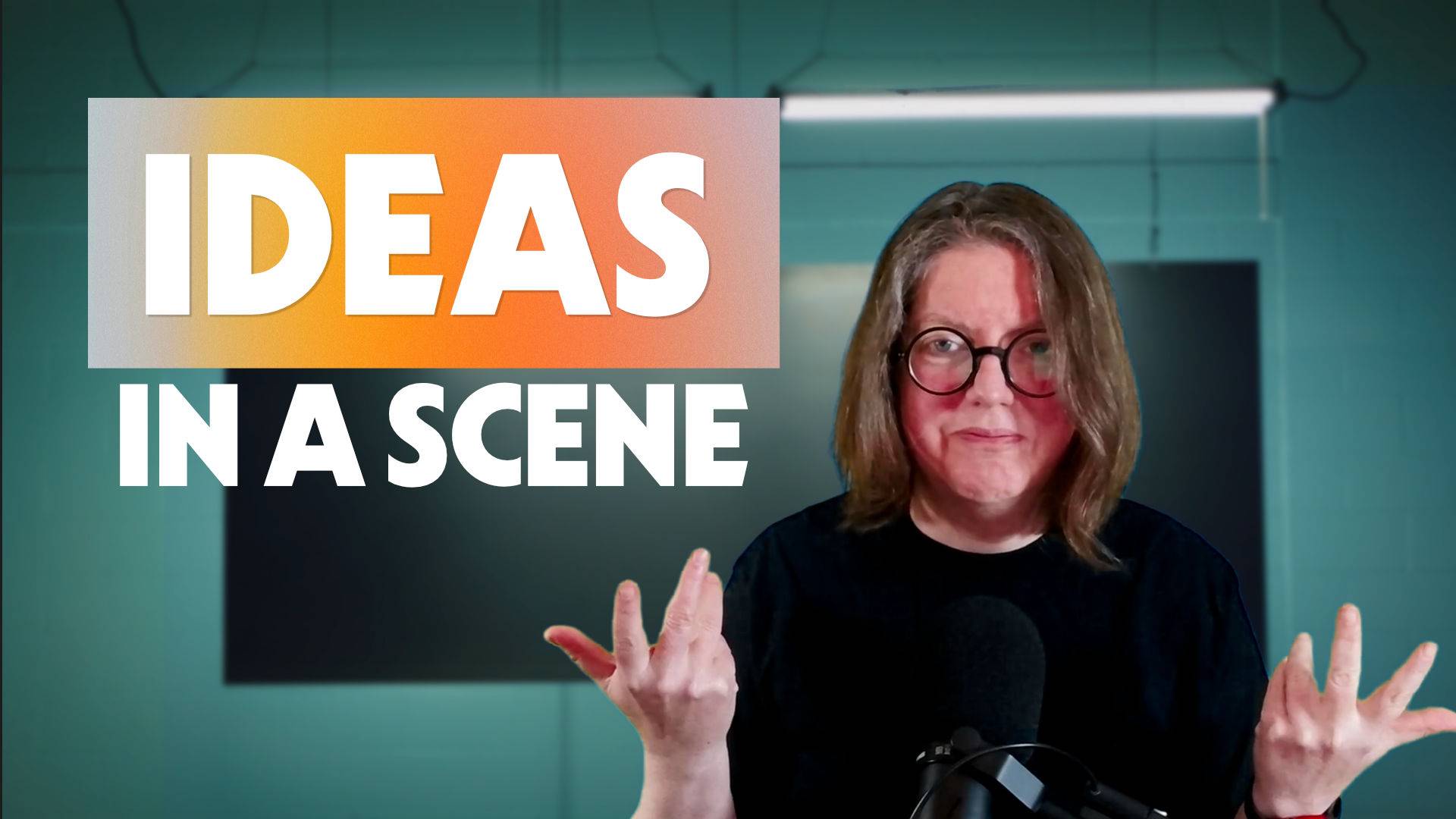 Jen standing at a microphone in front of a green wall with text beside her "Ideas in a Scene"