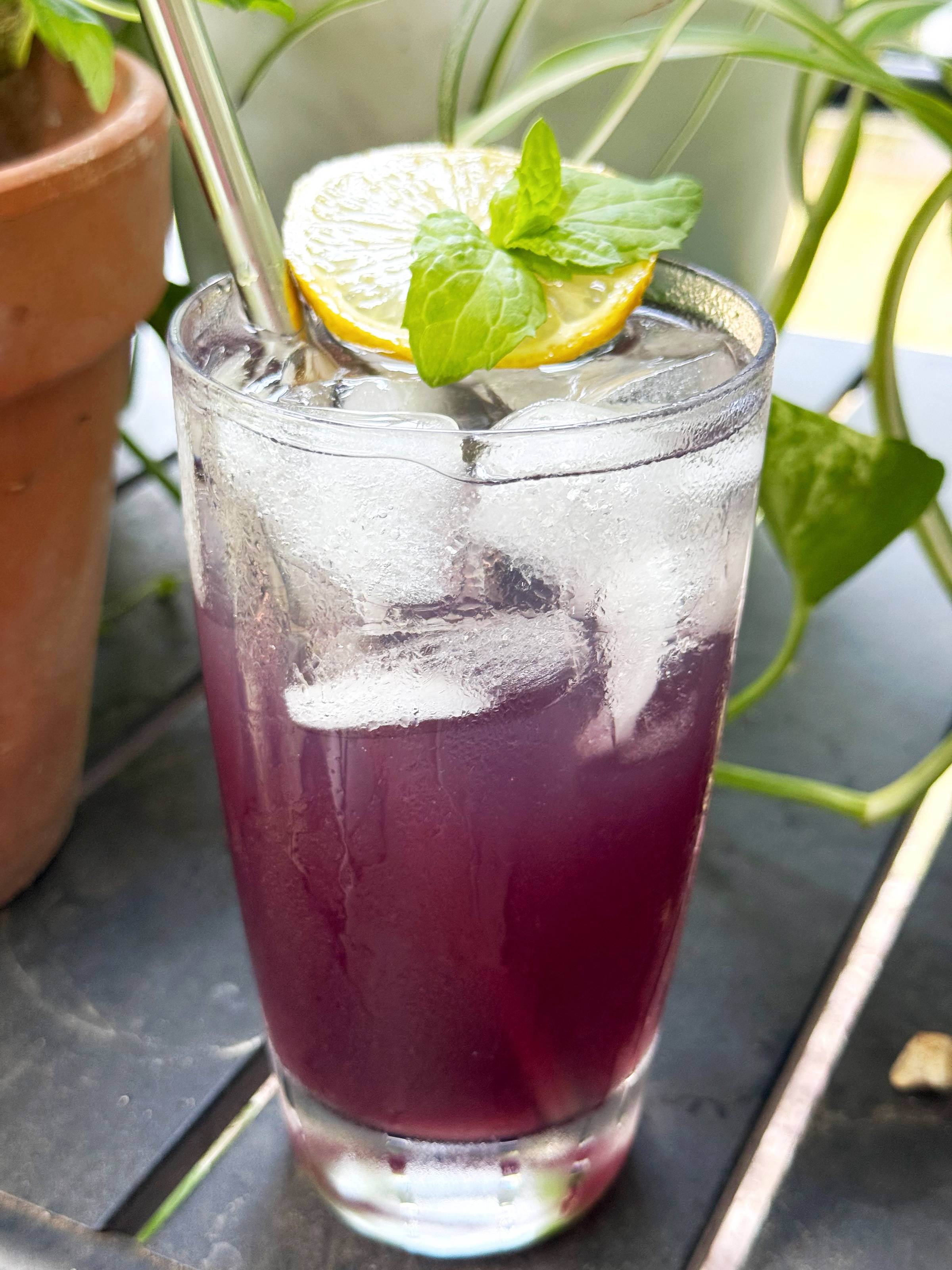 A lightly sparkling butterfly pea flower mocktail made with mandarin orange simple syrup, fresh lemon juice, and a small splash of lemon seltzer.