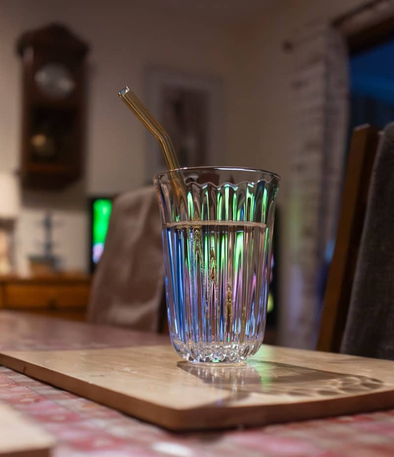 Glass of water with straw on table