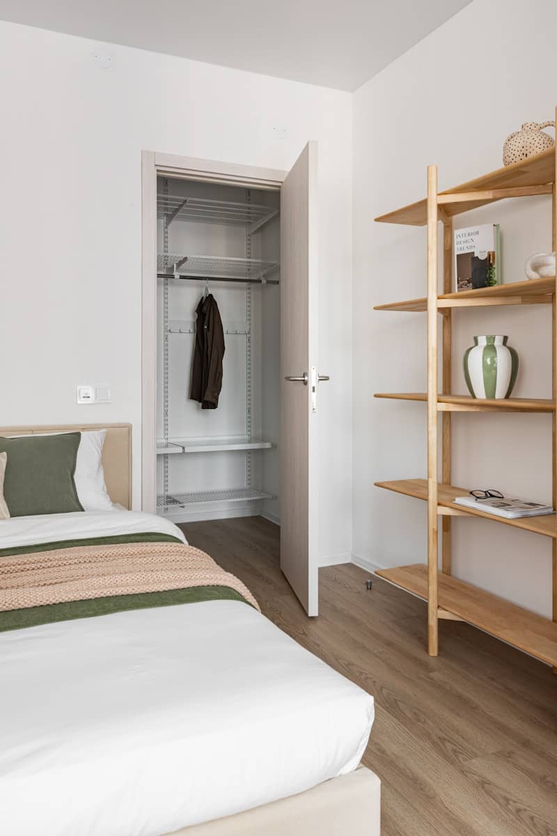 Bedroom with open closet and wooden shelves