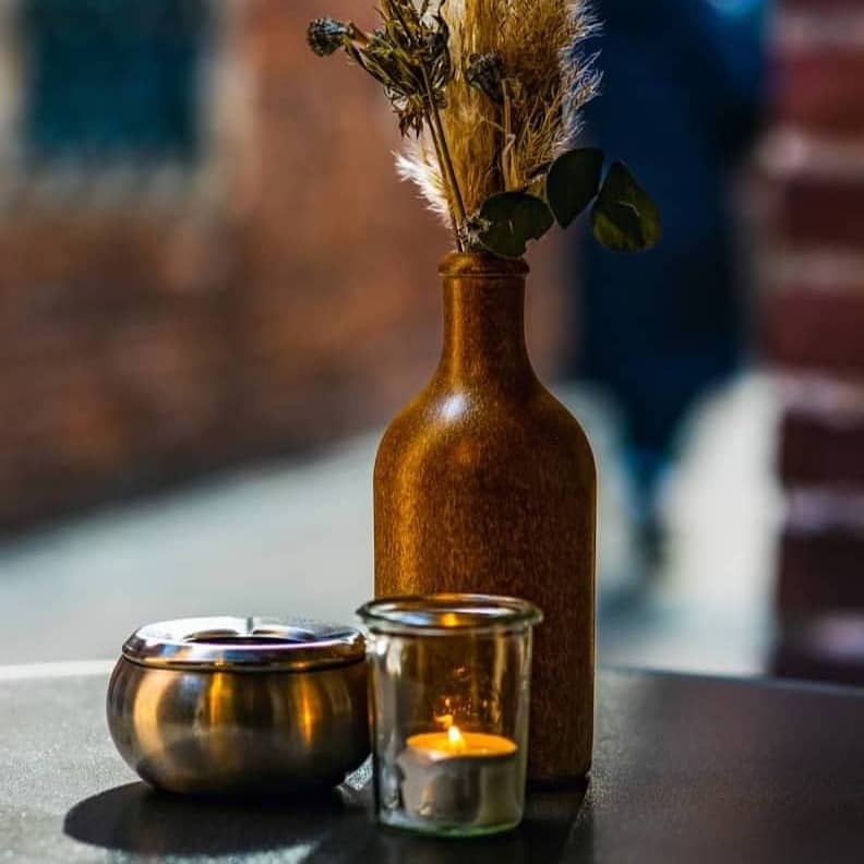 Vase, candle, and ashtray on a table.