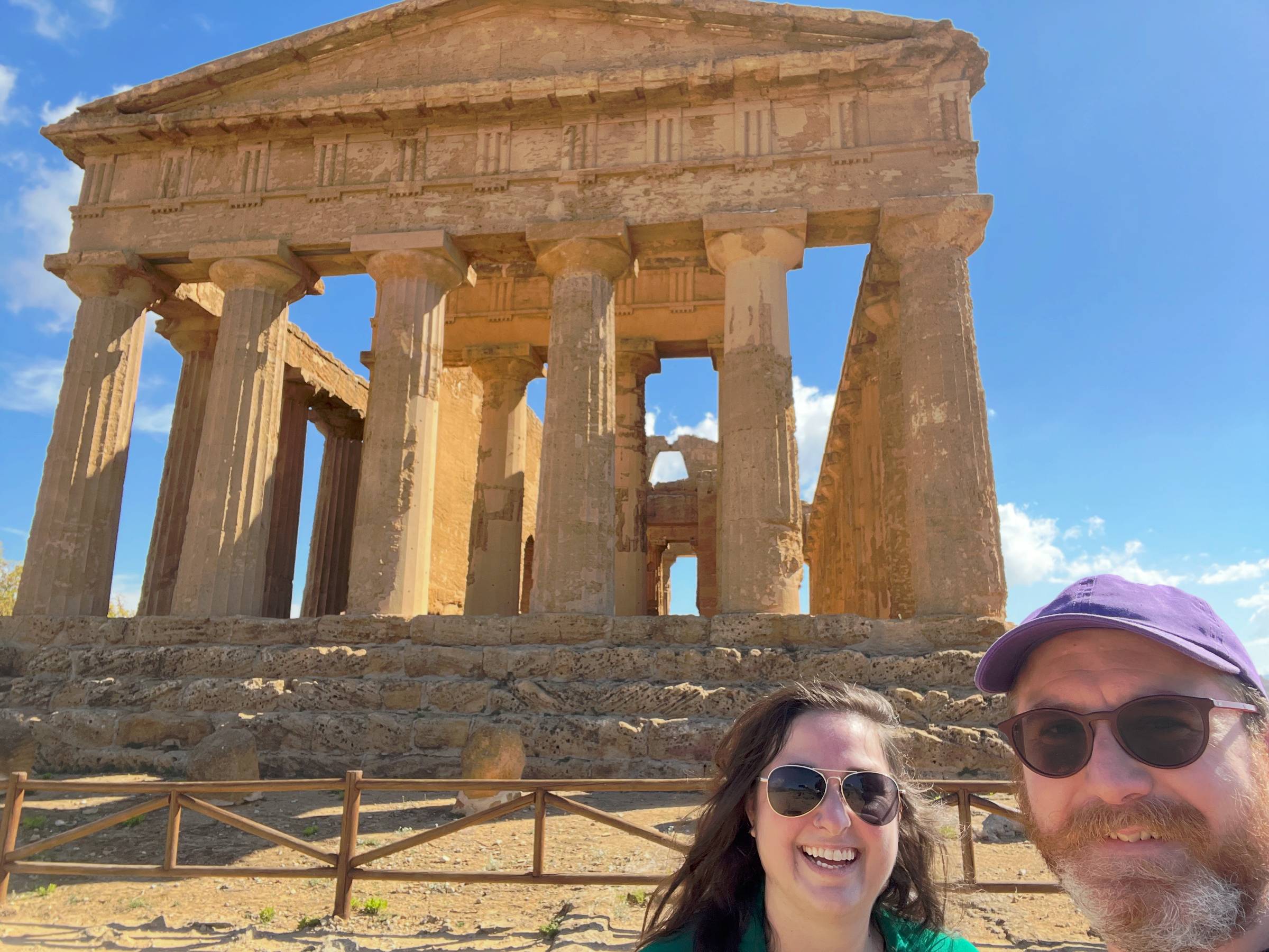 Carolyn and her husband in front of an ancient Greek temple