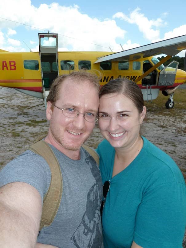 Carolyn and her husband in front of a tiny plane in Guyana