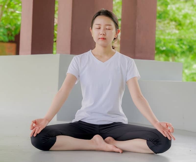 a woman is sitting in a lotus position