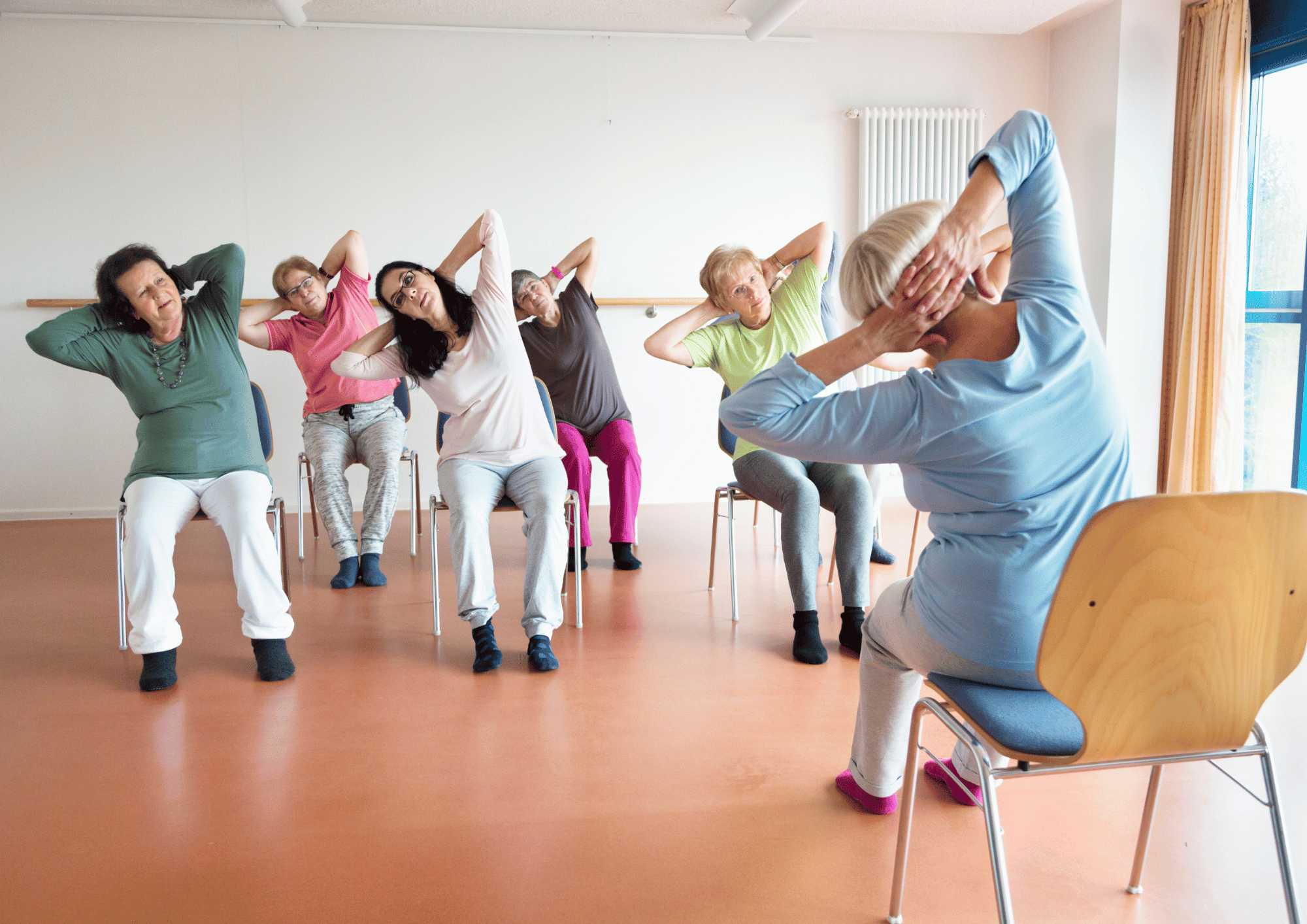 Chair yoga class in a side bend, hands behind heads