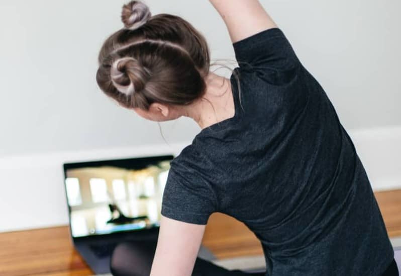 woman in black t-shirt and black pants lying on black yoga mat