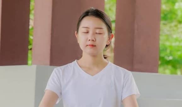 a woman is sitting in a lotus position