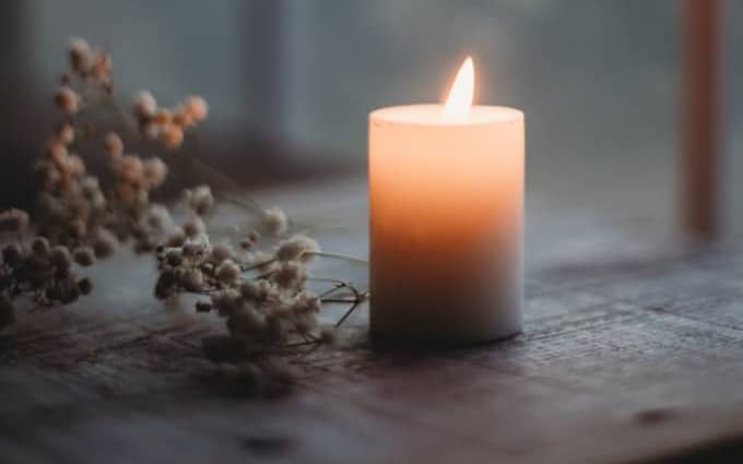 a lit candle sitting on top of a wooden table
