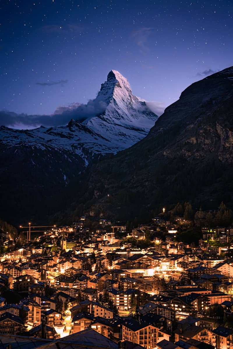 Night view of a town under a starry mountain.