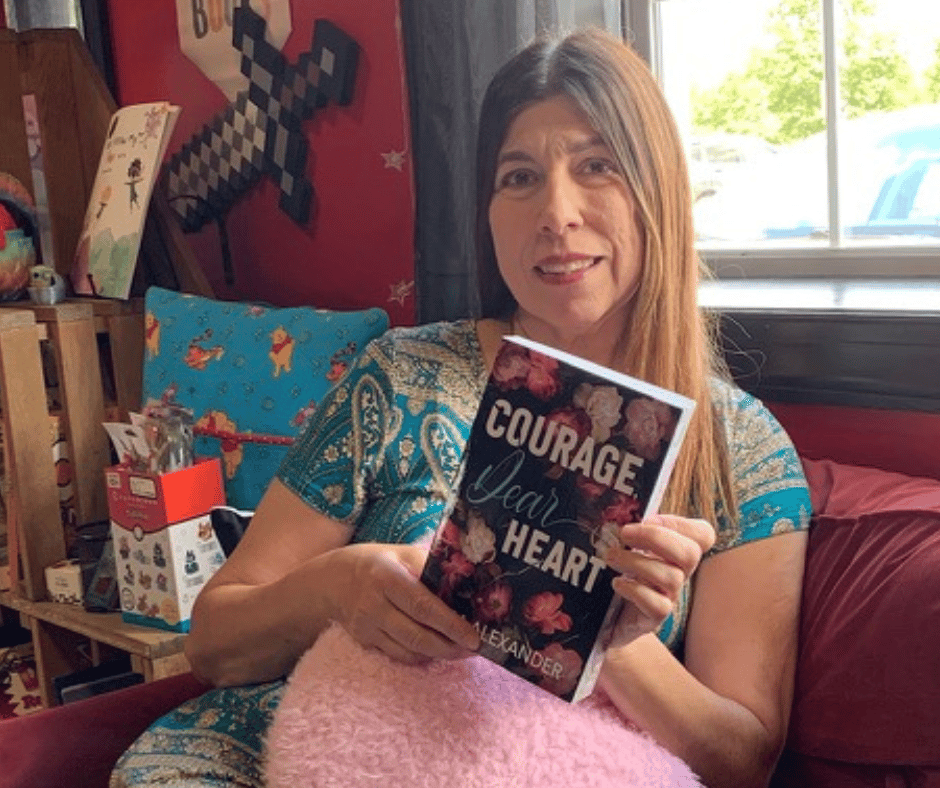 Erica Alexander holding a paperback of Courage, Dear Heart