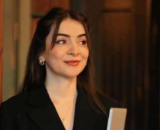 A woman in a black suit holding a folder