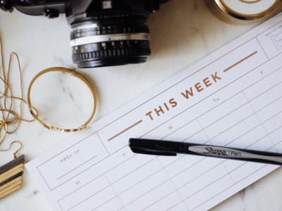 a weekly planner page with a pen; camera in the upper part of the image, partially out of view
