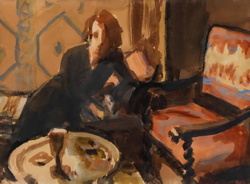Woman in a dark dress sits by a chair.
