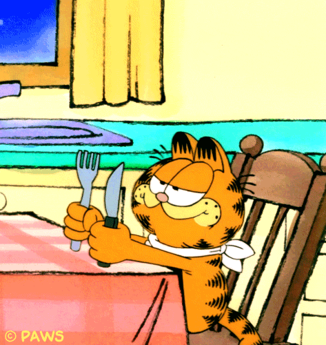 An overly hungry Garfield the cat at the table.