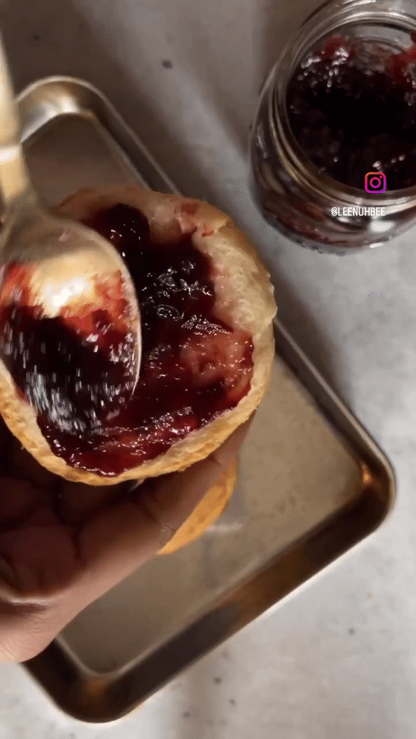 spreading grape jam on a buttermilk biscuit
